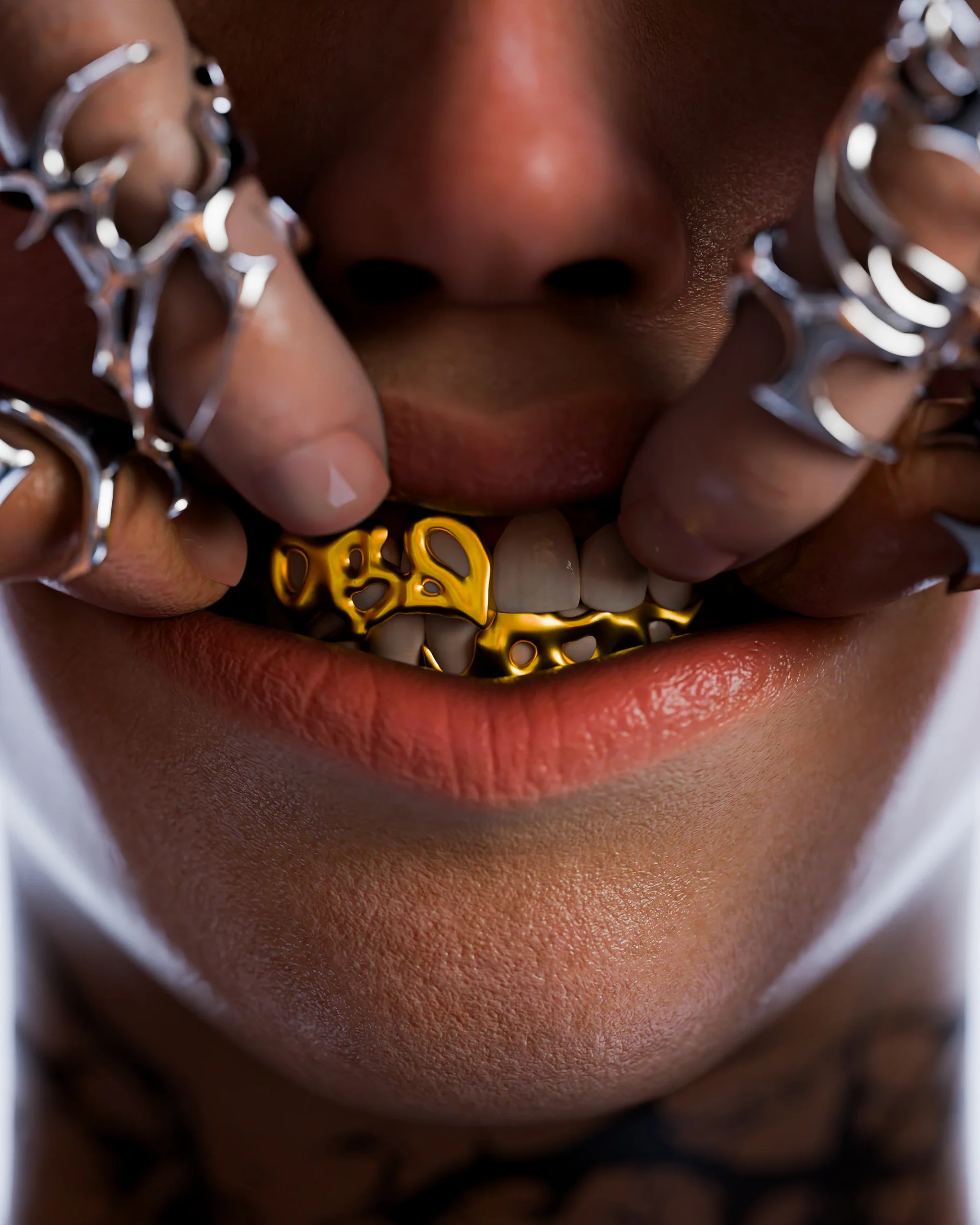 Gold grillz framed by chrome finger jewelry